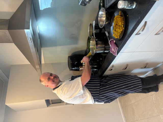 Professional chef cooking at the stove during batch cooking session